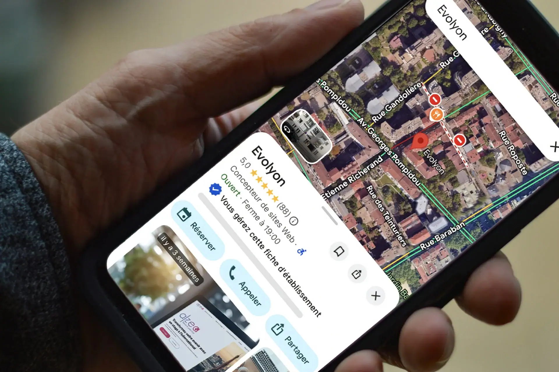 Smartphone tenu en main affichant la fiche d’un établissement sur Google Maps